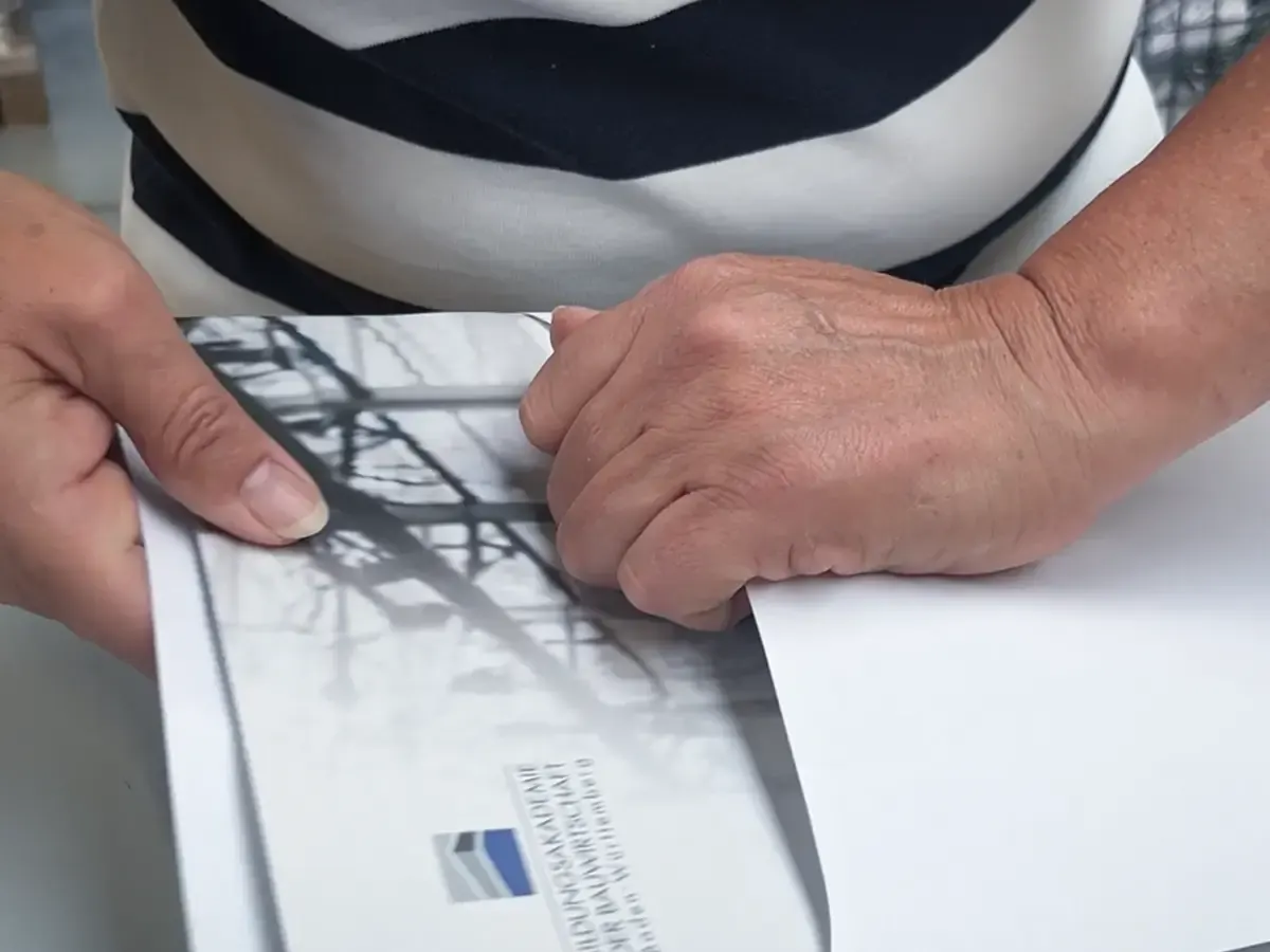 Hände beim manuellen Konfektionieren eines Mailings